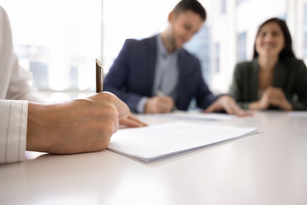 locataire remettant un chèque au propriétaire lors de la signature d'un bail, moment de confiance
