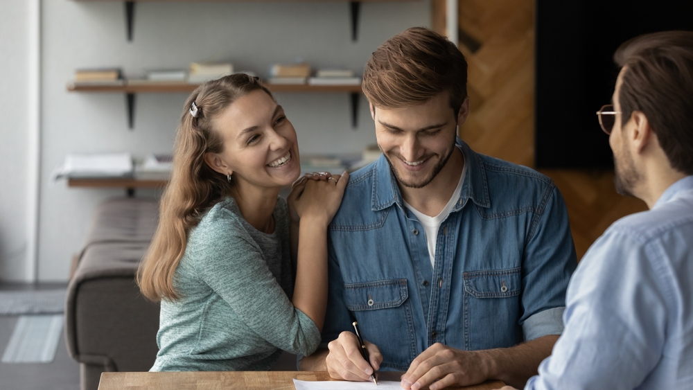 personne signant un document de procuration à son domicile, stylo en main, ambiance sérieuse et organisée